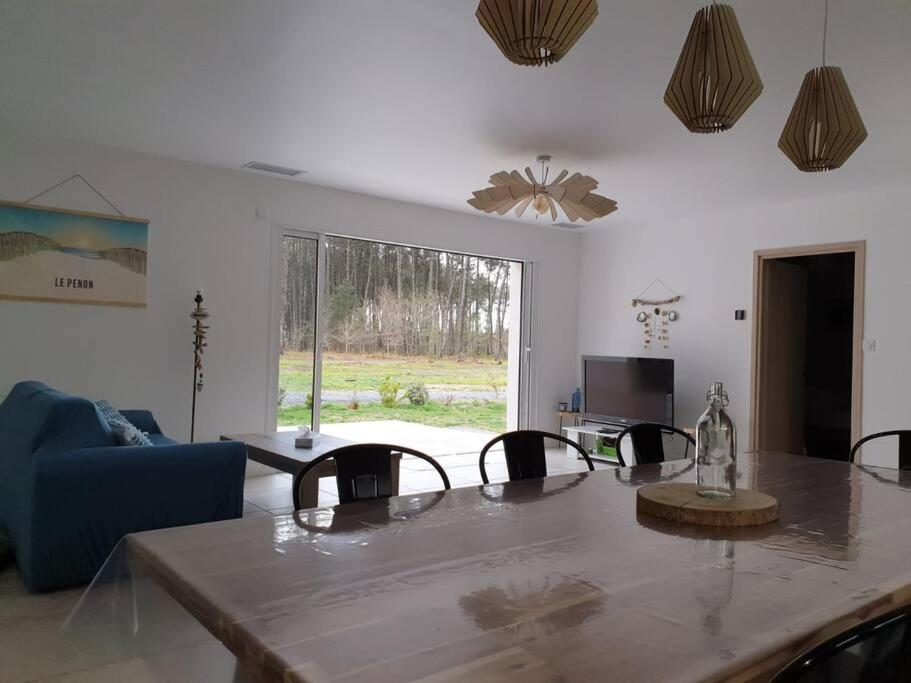 sala de estar con mesa, sillas y sofá en Maison neuve proche du lac de Léon et de l'Océan, en Vielle-Saint-Girons