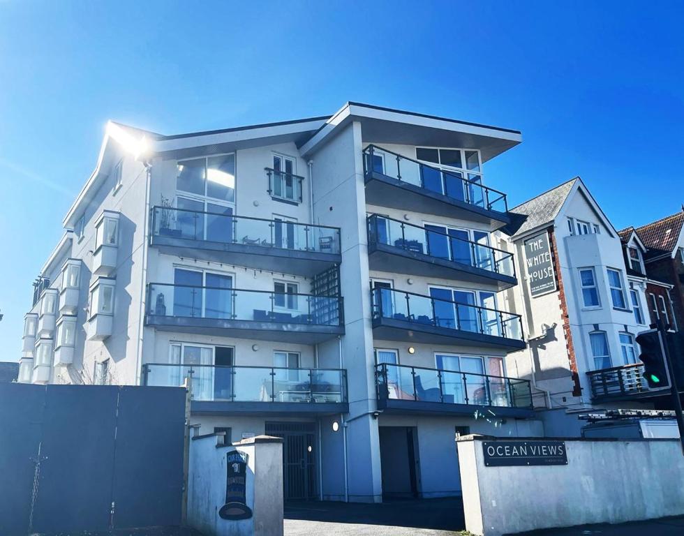 a tall white building with balconies on it at 6 Ocean Views in Newquay