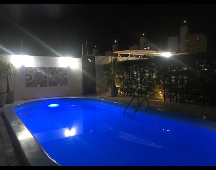 ein blauer Swimmingpool bei Nacht mit einem Gebäude in der Unterkunft Apartamento em Mossoró in Mossoró