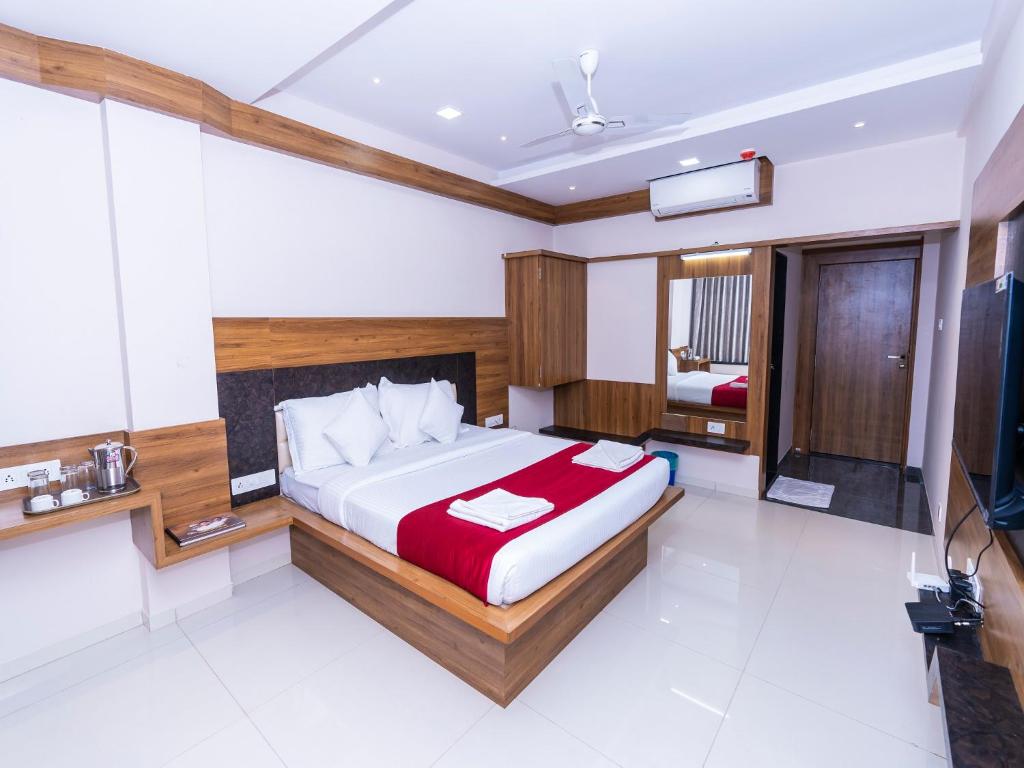 1 dormitorio con 1 cama y TV. en Hotel Chiranjeevi Kolhapur en Kolhapur