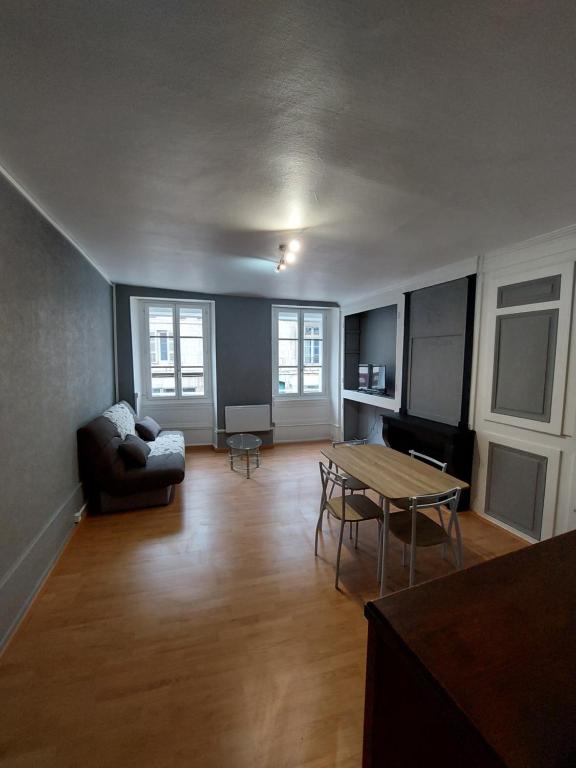 a living room with a table and a couch at Appartement Le Suly in Salins-les-Bains