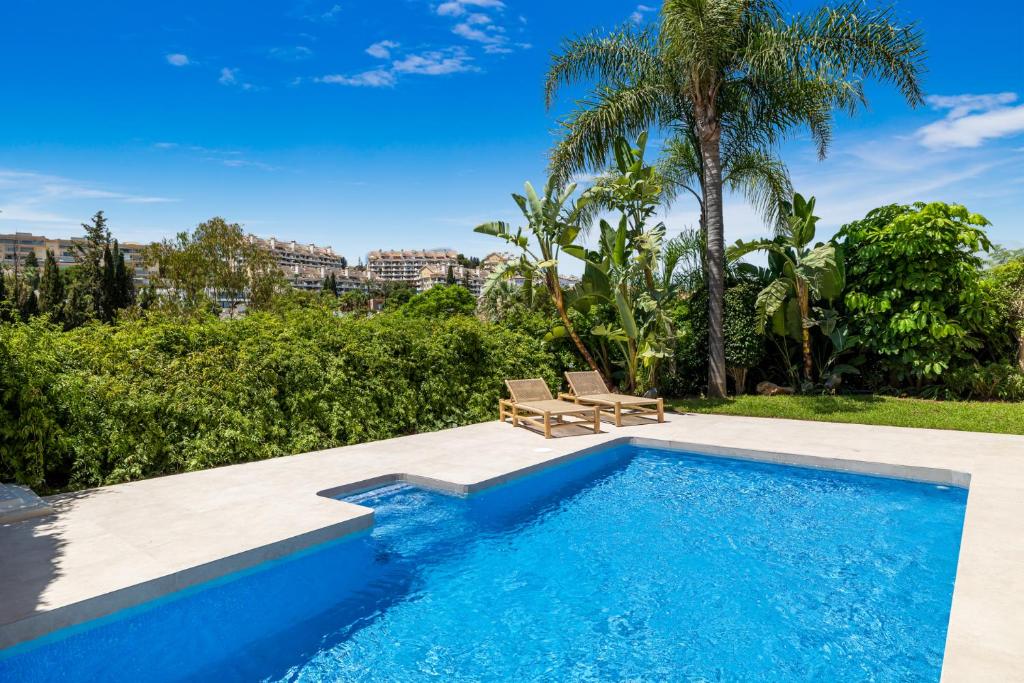 una piscina con un banco junto a un complejo en VACATION MARBELLA I Villa Vasari, Near Marina, Private Pool, Rooftop Views, Big Groups, en Marbella