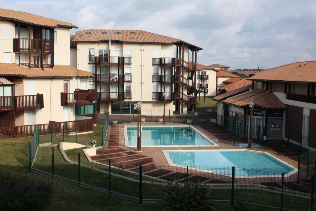 a swimming pool in front of some apartment buildings at Appartement Vieux Boucau in Vieux-Boucau-les-Bains