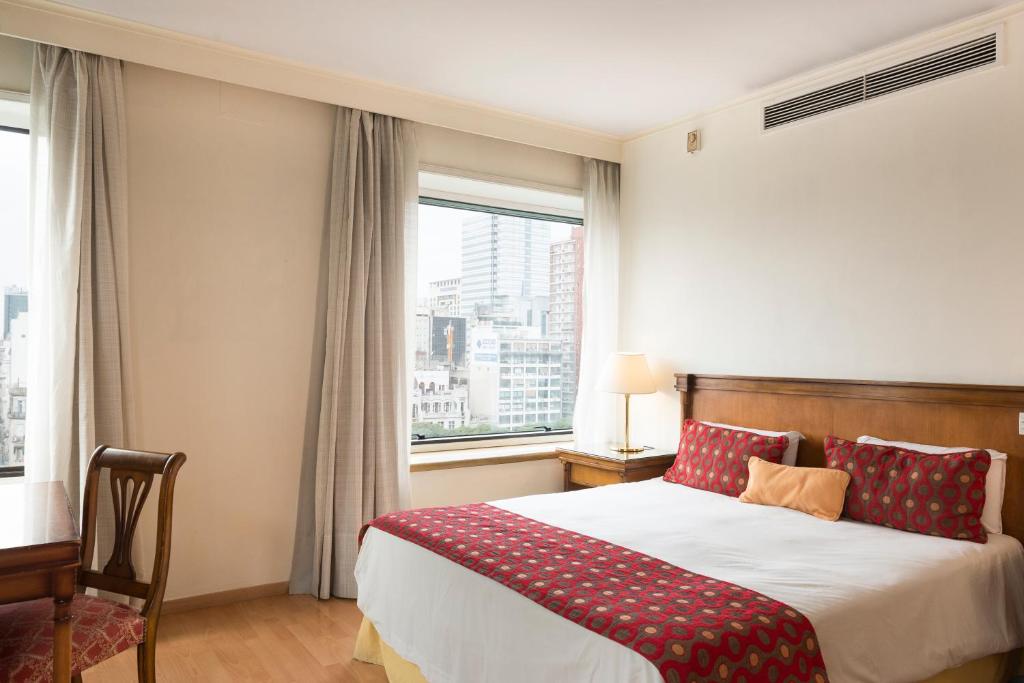 a bedroom with a bed and a large window at Imperial Park Hotel in Buenos Aires