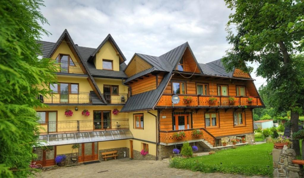 duży drewniany dom z dachem gambrel w obiekcie Pokoje Cichy Kącik w Zakopanem