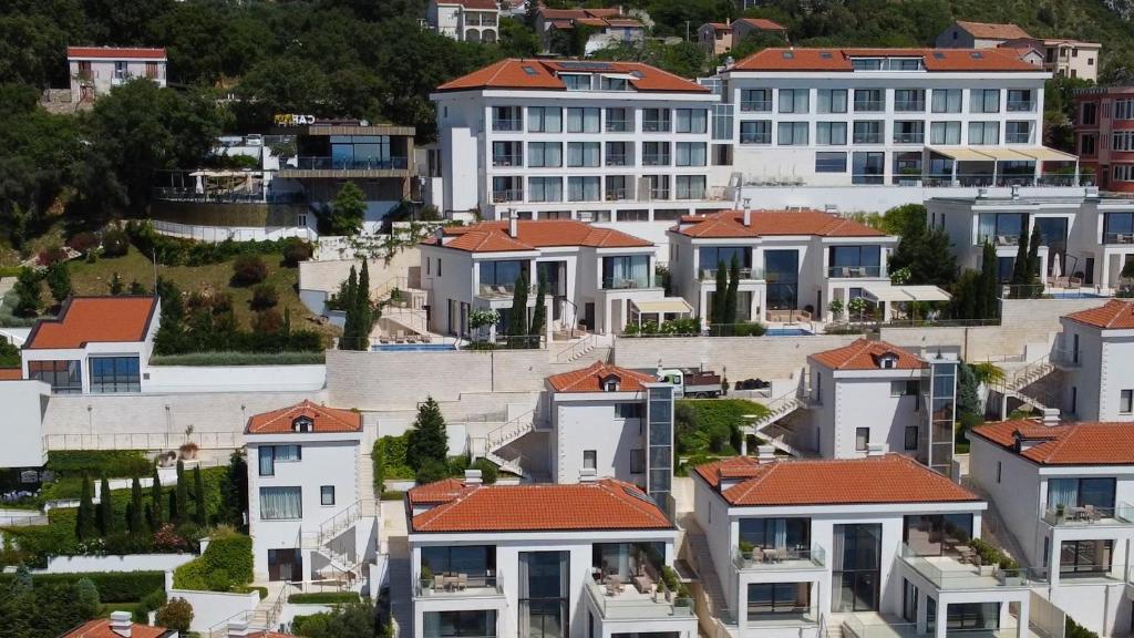 un groupe de maisons au toit rouge dans l'établissement ĀNANTI Resort, Residences & Beach Club - The Leading Hotels of the World, à Sveti Stefan