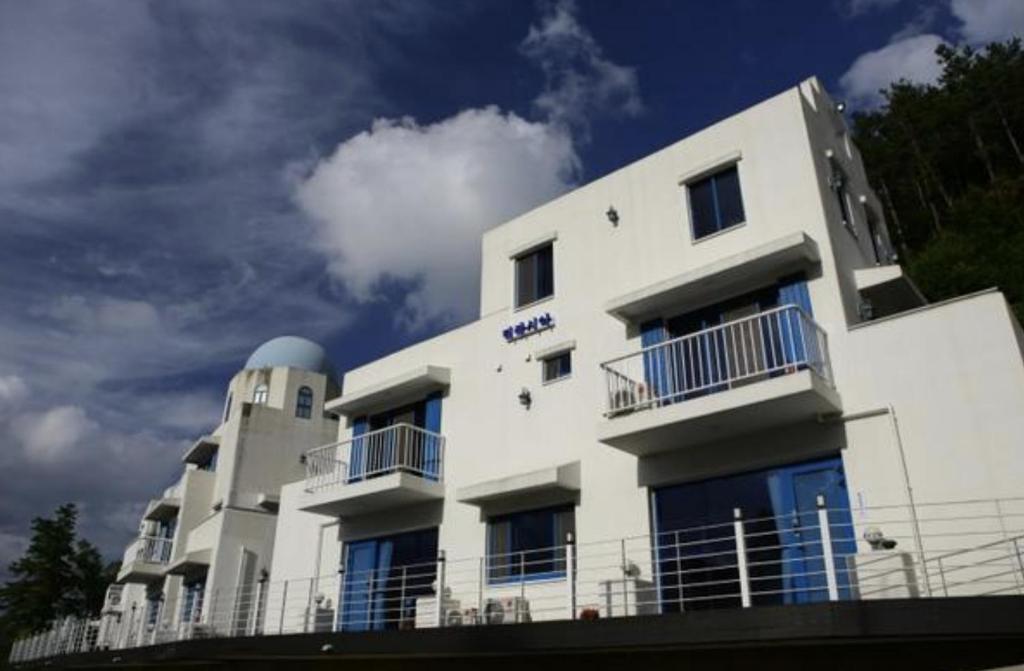 un edificio blanco con balcones en un lateral en Damyang Thirasia Pension en Damyang