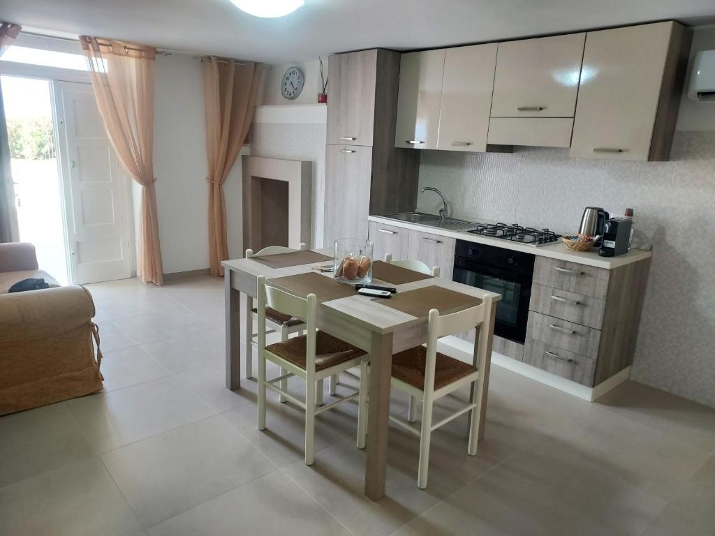 a kitchen with a table and chairs and a kitchen with a stove at Villa Capitani in Torre Canne