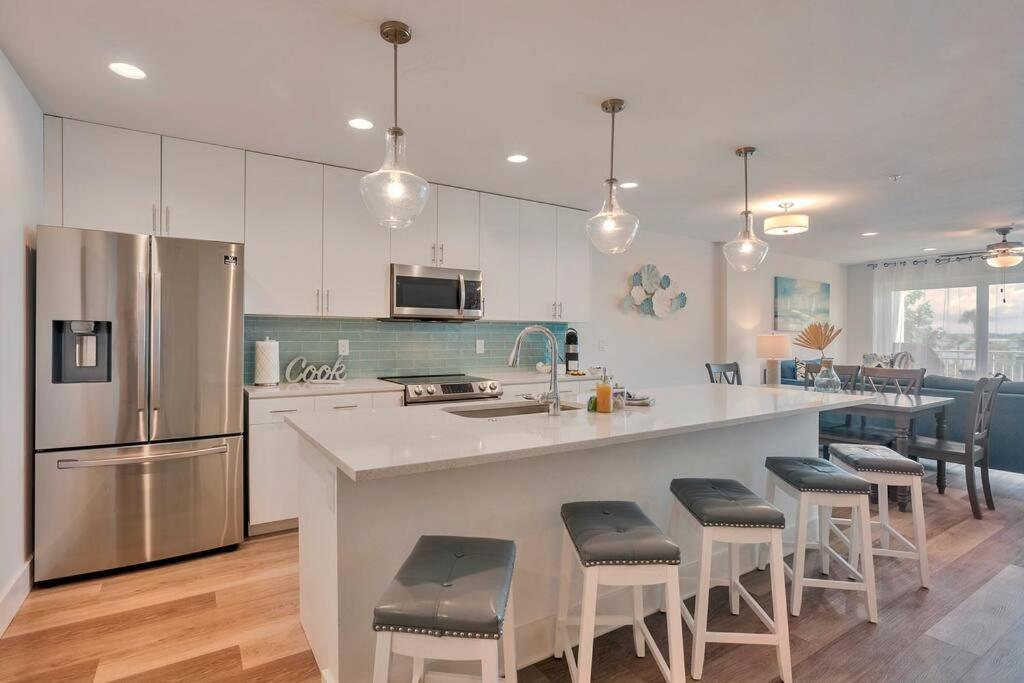 a kitchen with a large island with bar stools at New Luxury Condo w/ Heated Pool 1 Block From Gulf in St. Pete Beach