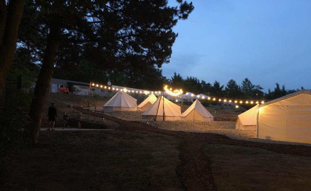 rząd białych namiotów z oświetleniem w obiekcie Anastazewo Port and Resort w Powidzu