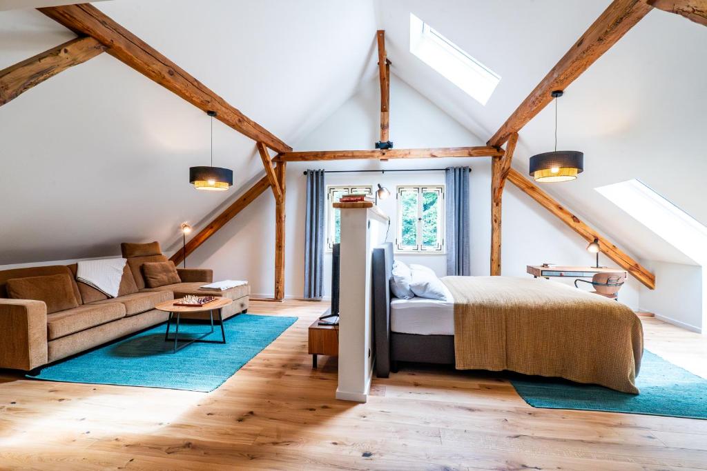 a loft bedroom with a bed and a couch at Landwarenhaus Gross Beuchow in Groß Beuchow