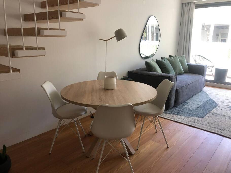 ein Wohnzimmer mit einem Tisch, Stühlen und einem Sofa in der Unterkunft Oasis 28 by Innkeeper in Lissabon