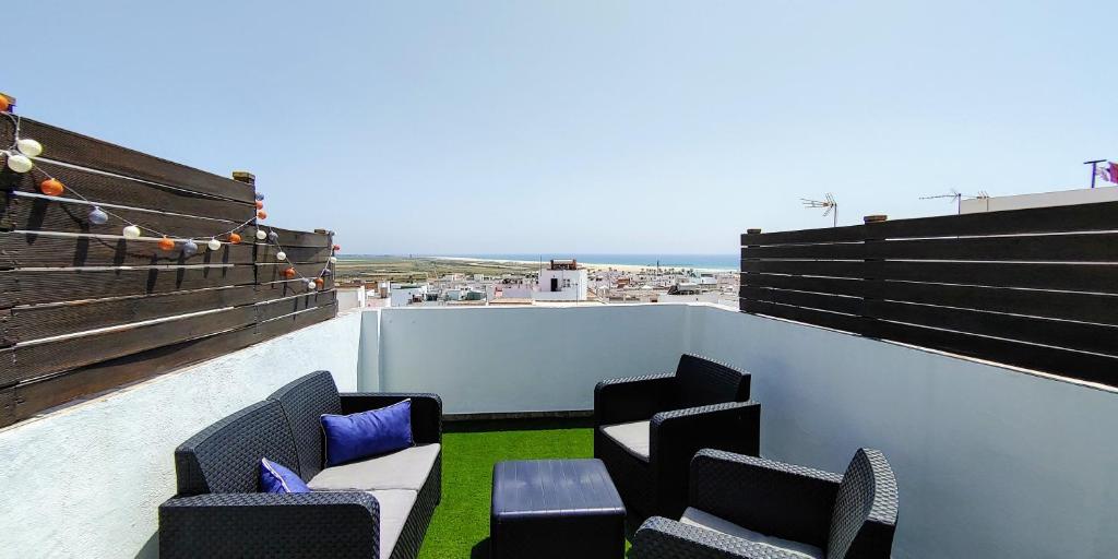 uma varanda com cadeiras e vista para o oceano em Casa Vistas a Trafalgar sólo familias o parejas - Parking privado opcional - em Conil de la Frontera
