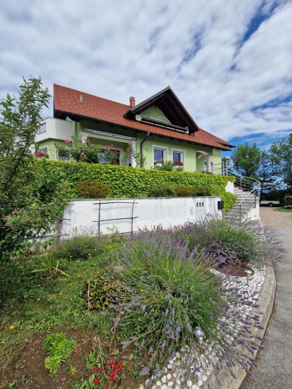 uma casa no topo de uma colina com uma cerca em Green House Apartment em Pivka