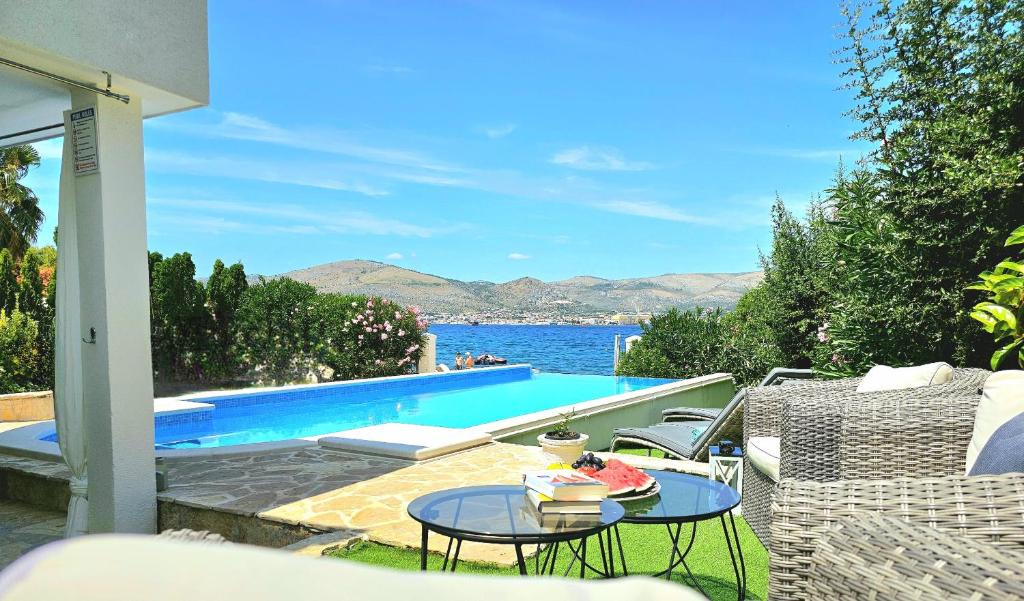 patio con tavolo e piscina di Villa Palace Al Nera a Trogir