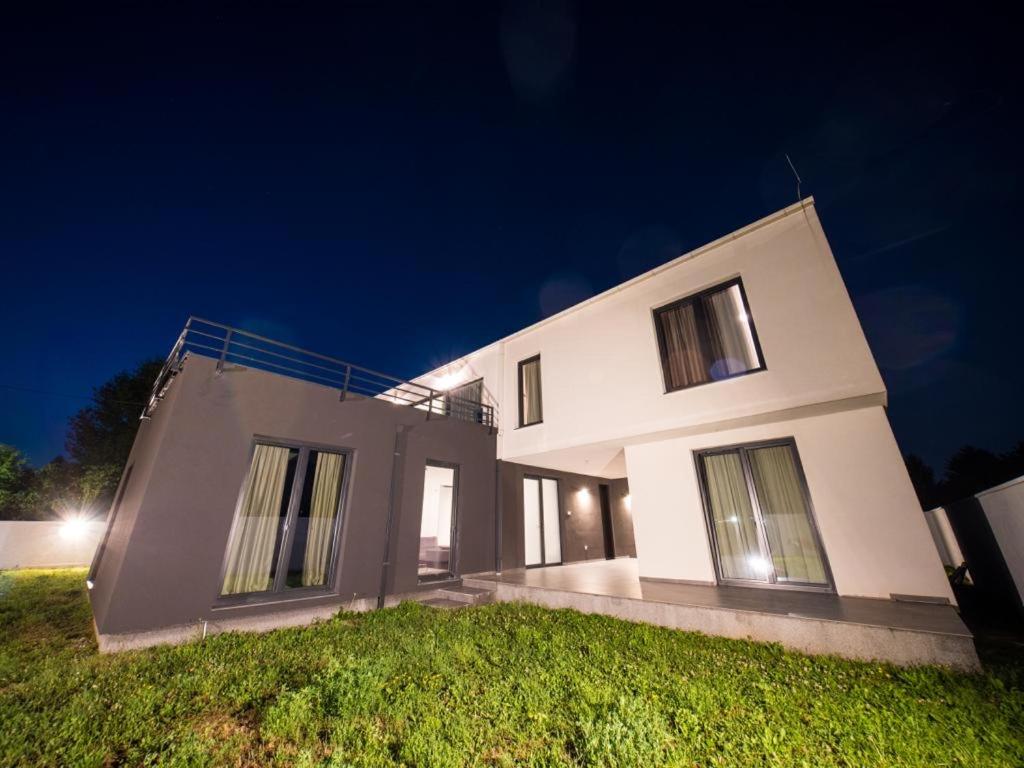 una gran casa blanca por la noche con un patio verde en Villa AURORA en Sarajevo