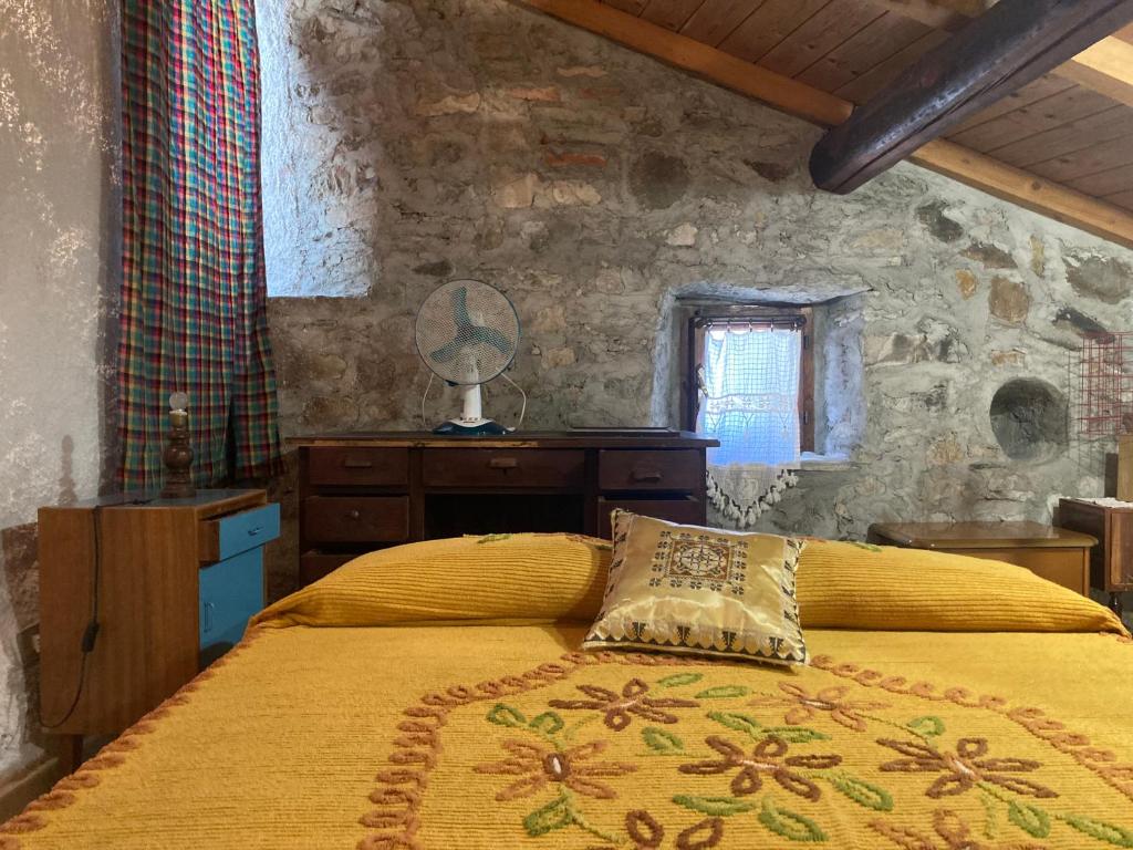a bedroom with a bed with a yellow comforter at LA VECCHIA STALLA in Varano