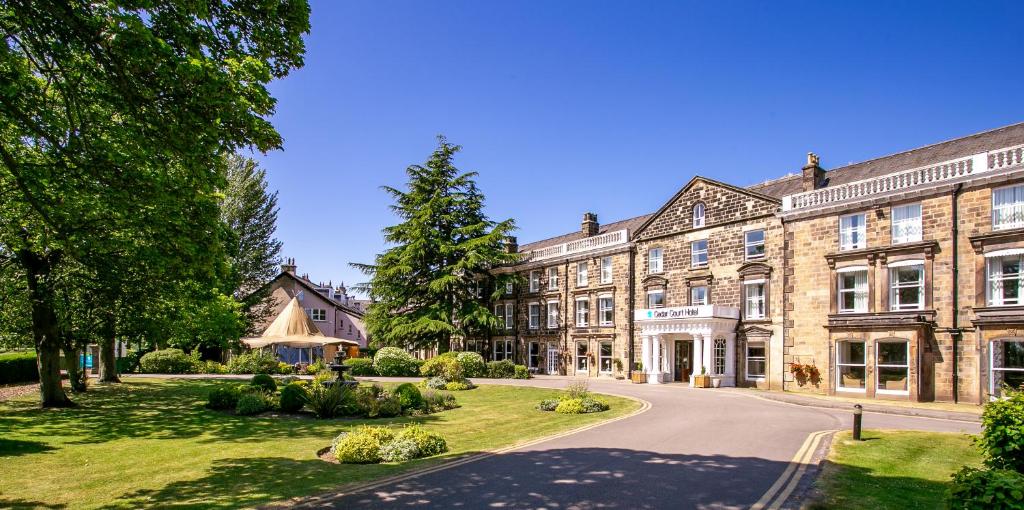 un gran edificio de ladrillo con una carretera delante de él en Cedar Court Hotel Harrogate, en Harrogate