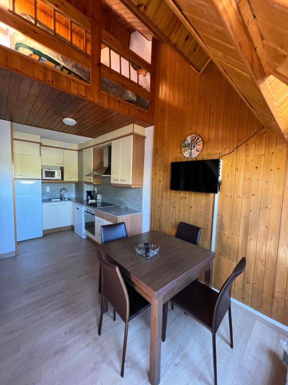 a kitchen and dining room with a wooden table and chairs at 2 ESCALES CONFORT in Pas de la Casa