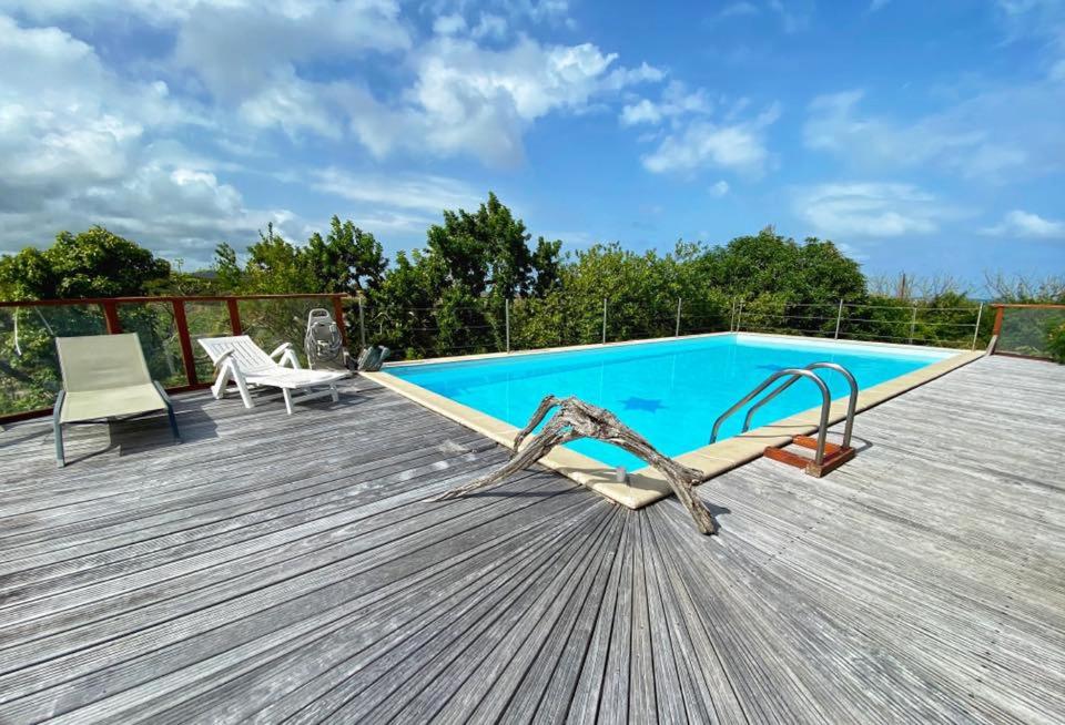 a deck with a swimming pool on top of a house at Domaine Macabou in Le Vauclin