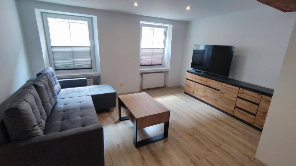 a living room with a couch and a flat screen tv at Stare Miasto in Kłodzko
