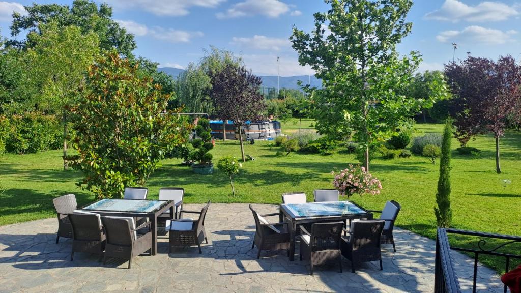 a patio with tables and chairs in a park at Green Villa Rodna in Skopje