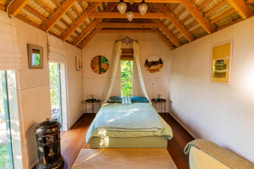MUHUSI Linnumaja في Igaküla: غرفة نوم بسرير في غرفة صغيرة