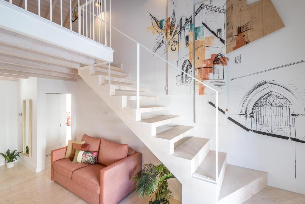 a staircase in a living room with a pink couch at LODO Suits Se - Mezanino room by HD in Faro