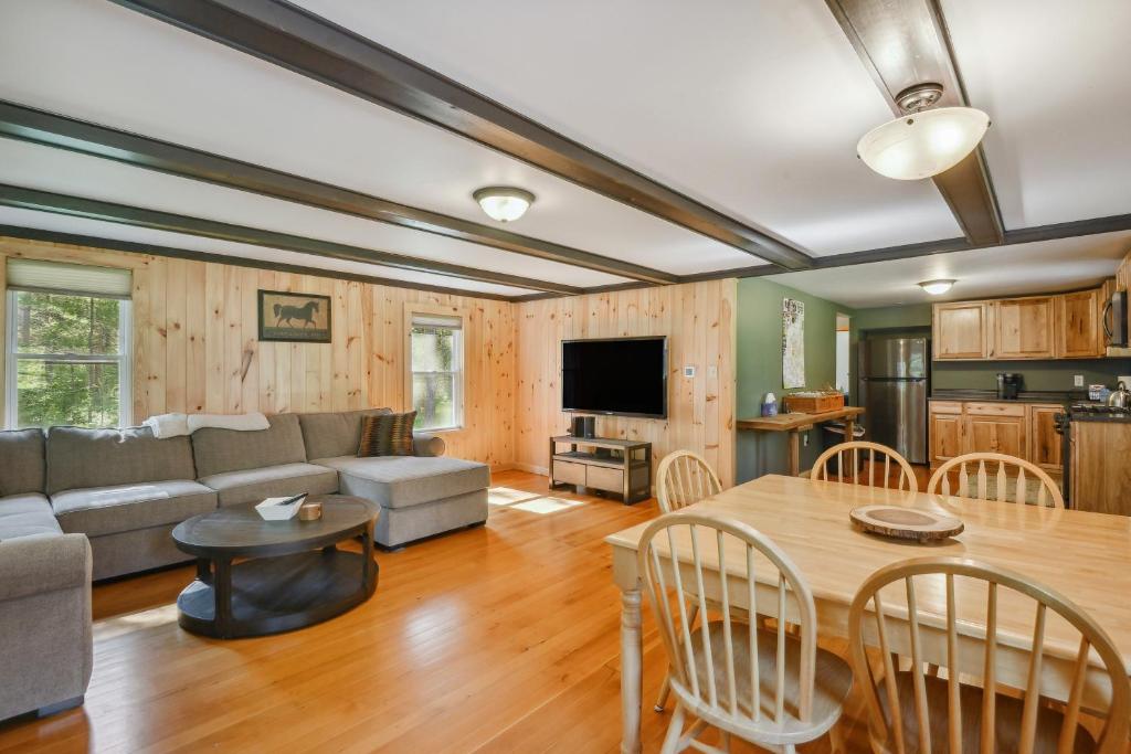 a living room with a couch and a table at Brantingham Cabin with Porch and Grill On 5 Acres! in Glenfield