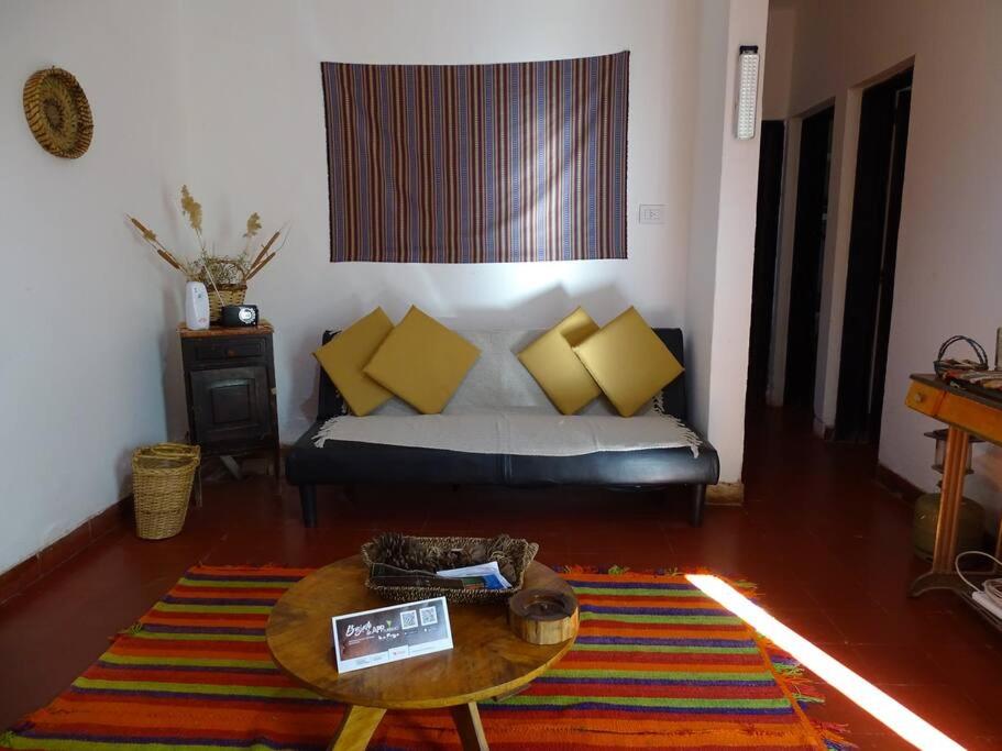 Una sala de estar con un sofá y una mesa de café. en Hostel, LA LULA, en Vinchina