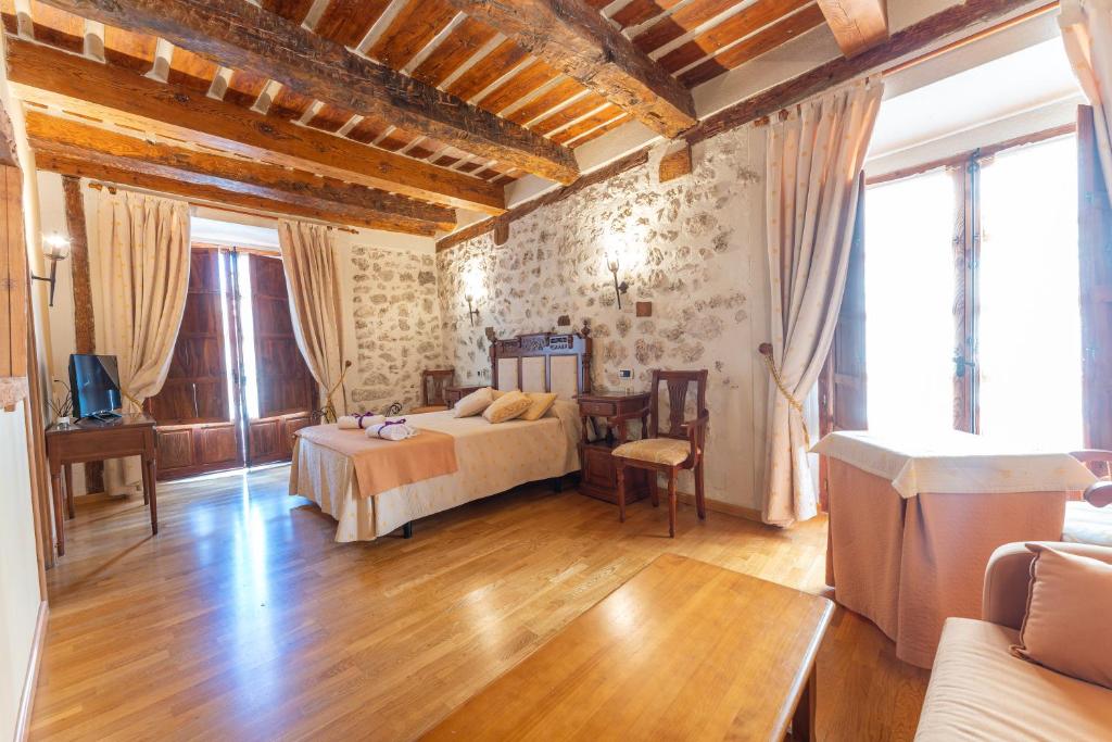 um quarto com uma cama e uma mesa num quarto em Hotel Rincón Castellano em Cuéllar