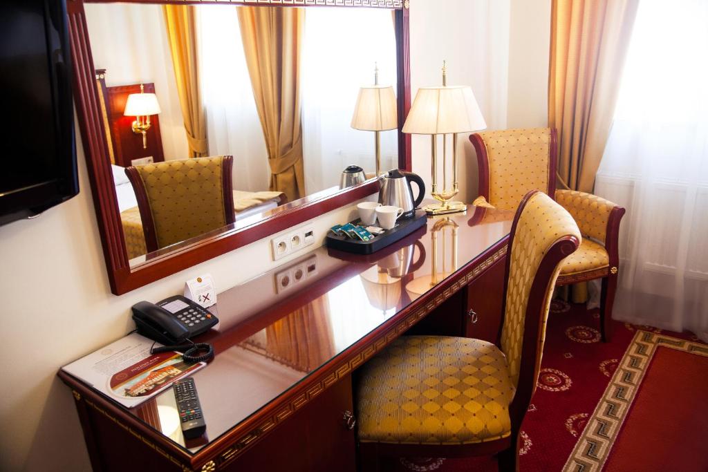 a hotel room with a desk and a mirror at Hotel Holiday Park in Warsaw