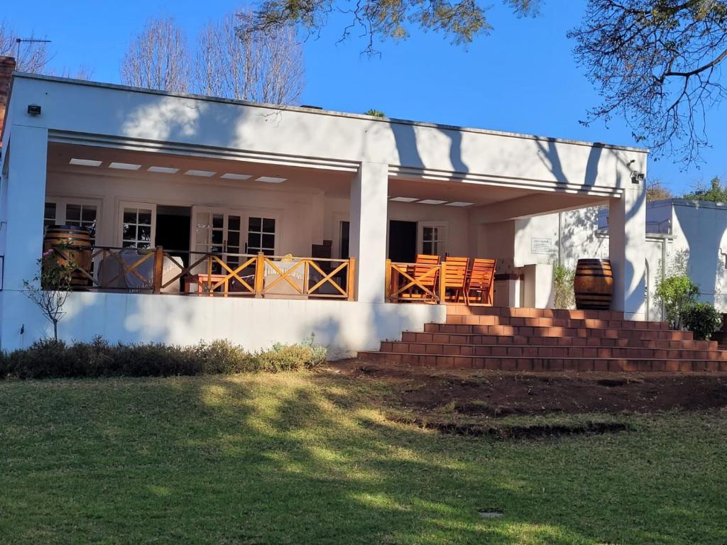 Casa blanca con porche y terraza en Eden Guesthouse, en Johannesburgo