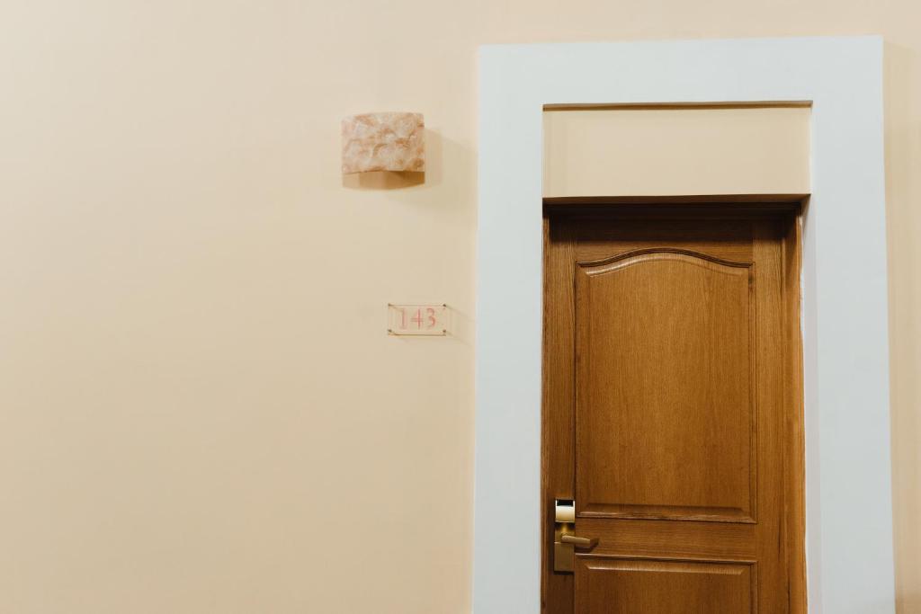 a wooden door in a white room next to a wall at Gran Hotel de Querétaro in Querétaro