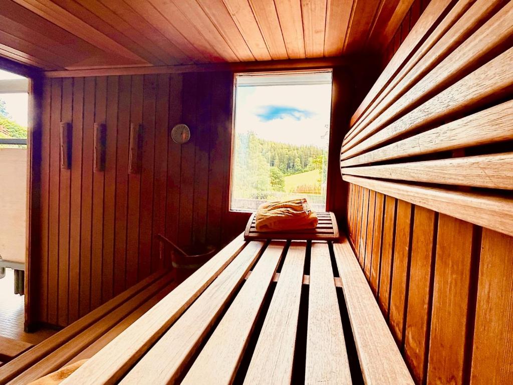 Habitación con banco en una habitación con ventana en Hotel Sonnenberg Garni, en Hinterzarten