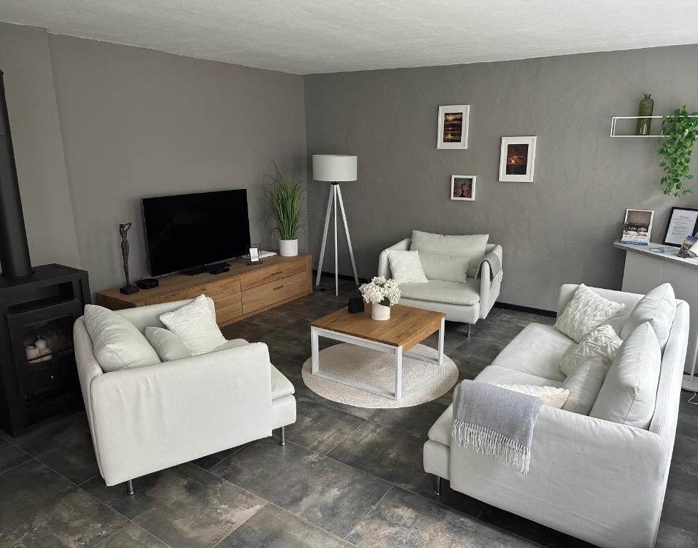 a living room with white furniture and a flat screen tv at Remise-Berlin-Grünau your cozy and comfortable home to stay for up to 6 people between Müggelsee and Berlin city in Berlin