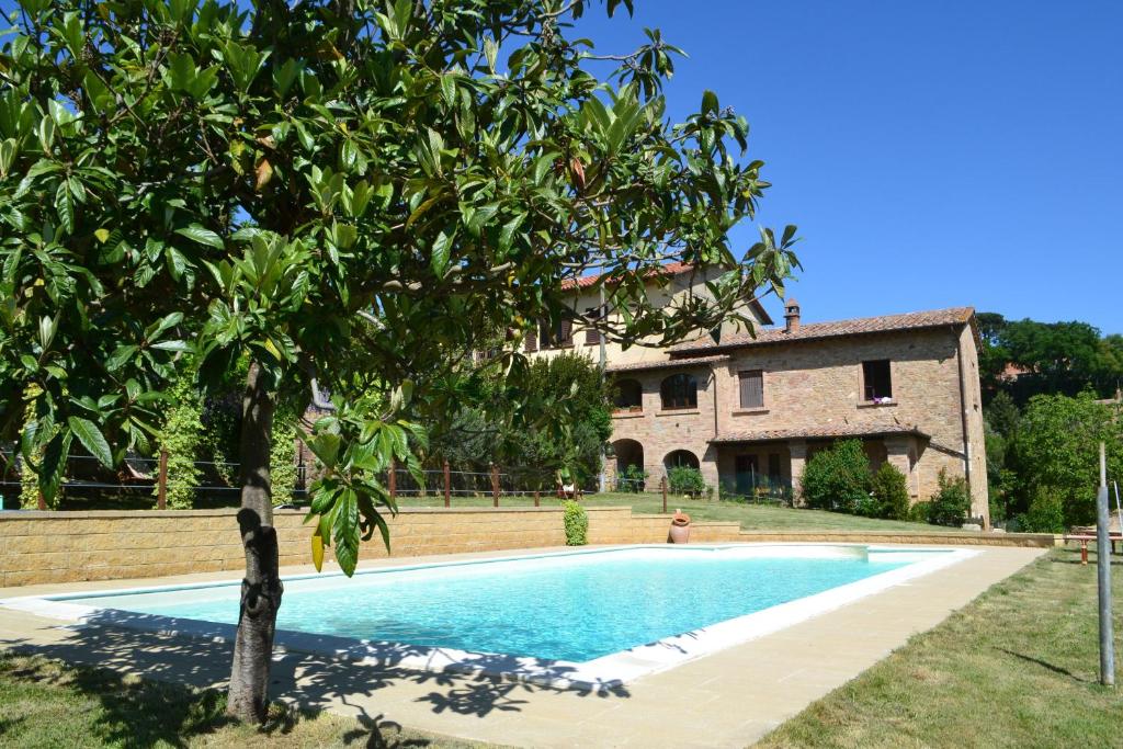 a swimming pool in front of a house at Podere Fontecastello in Montepulciano