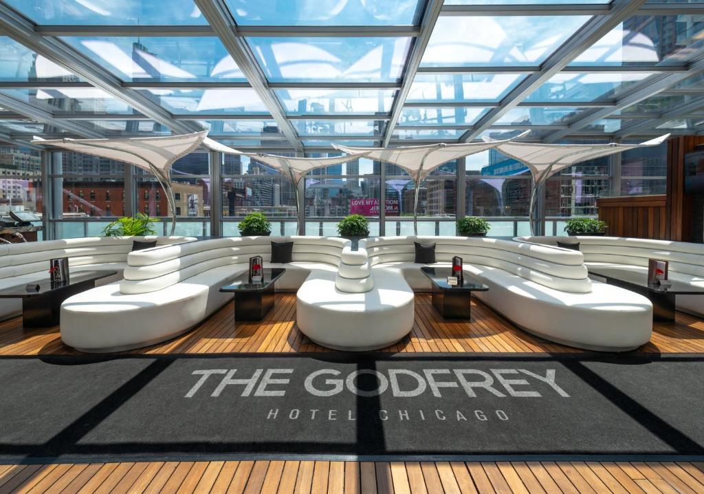 un hall avec des chaises et des tables blanches dans un bâtiment dans l'établissement Godfrey Hotel Chicago, à Chicago