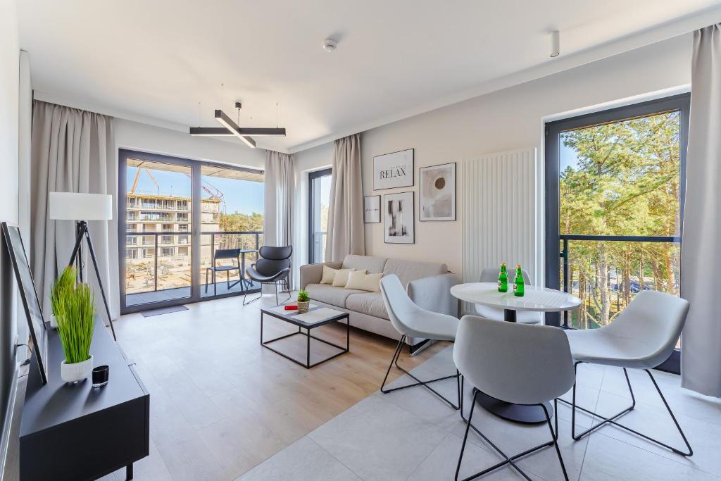 a living room with a couch and a table at Apartament Sunrise Shellter - Rogowo in Dźwirzyno