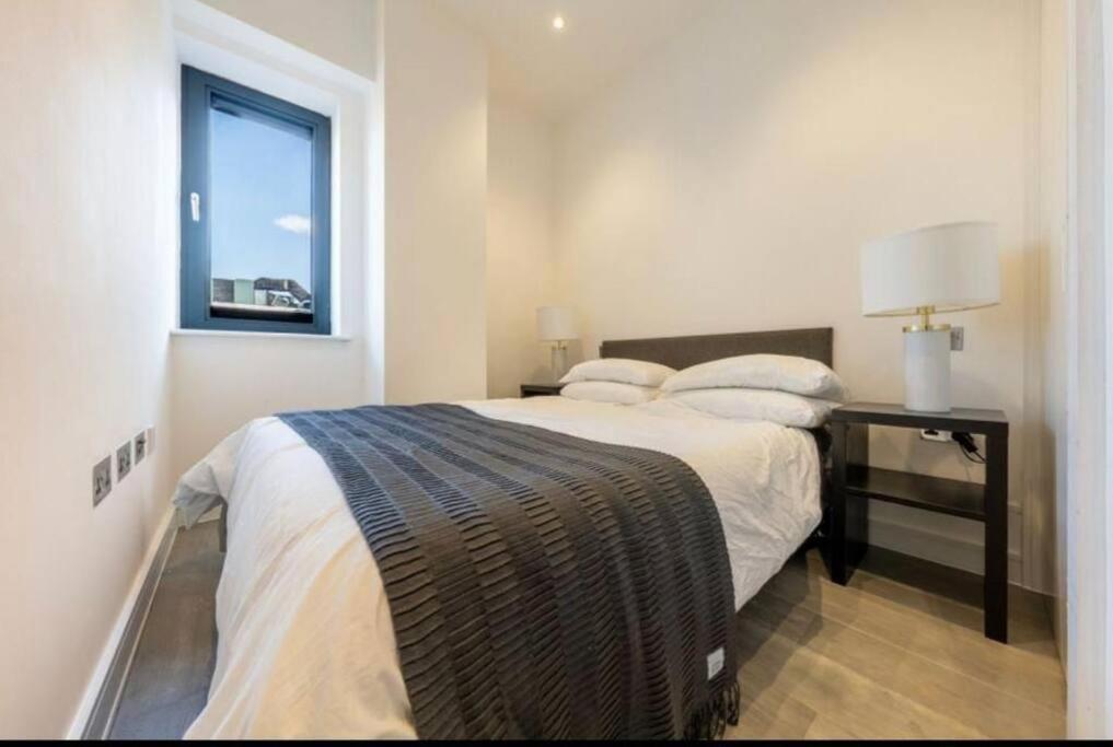 a bedroom with a bed with a desk and a window at 1 bed Apartment with parking & GYM in Slough