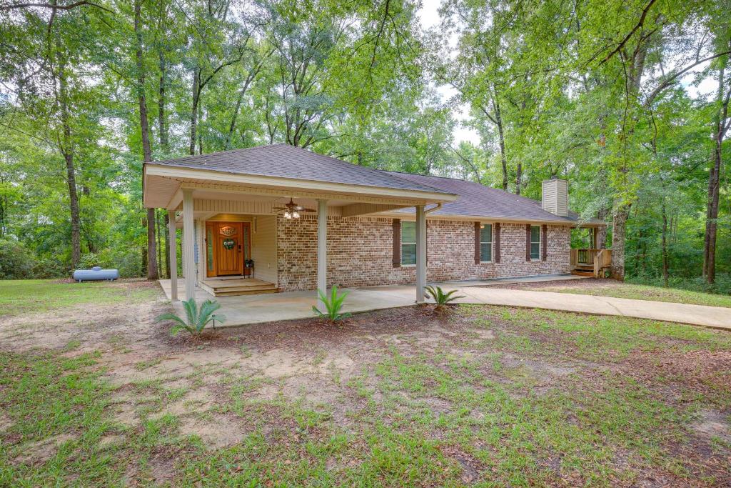 a home with a brick house with a porch at Peaceful Lucedale Hideaway on Private Acerage! in Lucedale