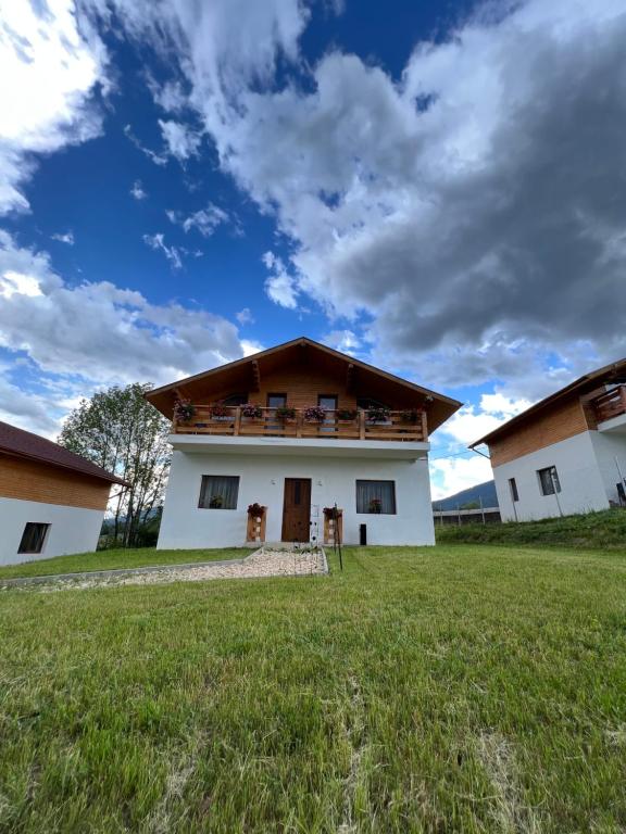 a house with a green field in front of it at CASA MARA CHALET & SPA Bran in Bran