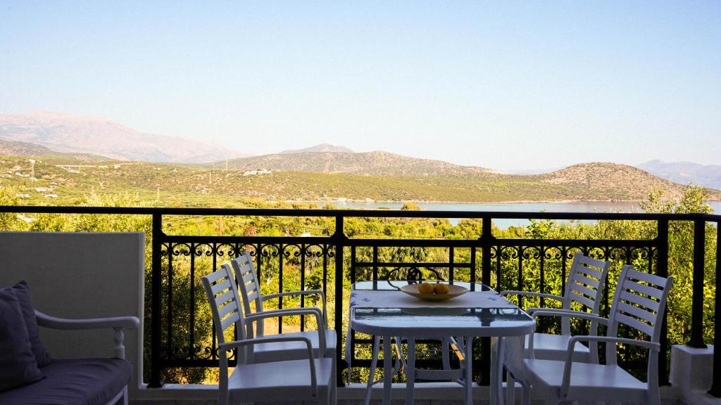 a table and chairs on a balcony with a view at Urban Blue House in Agios Nikolaos
