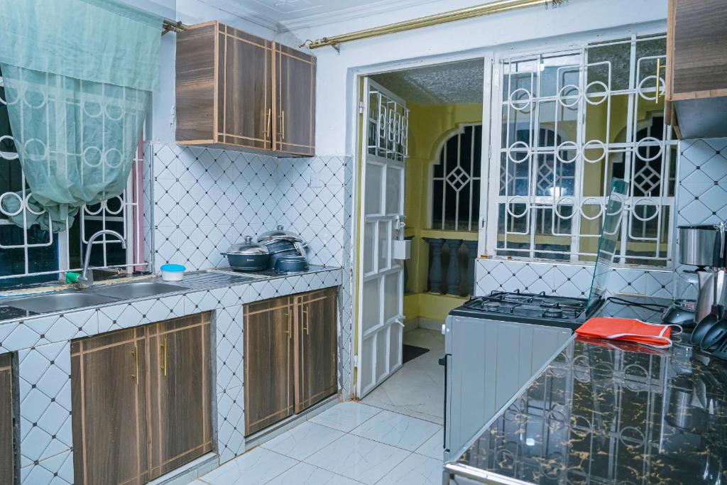 una cucina con armadi in legno e piano cottura. di Entire Fully furnished Villas in Kisii a Kisii