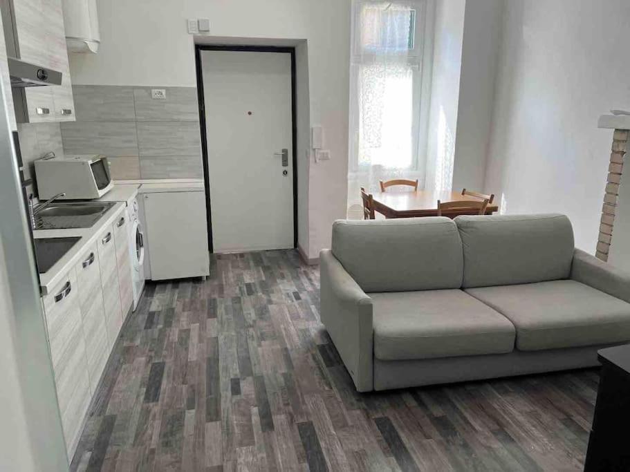 uma sala de estar com um sofá e uma cozinha em Palombino Apartment em Milão