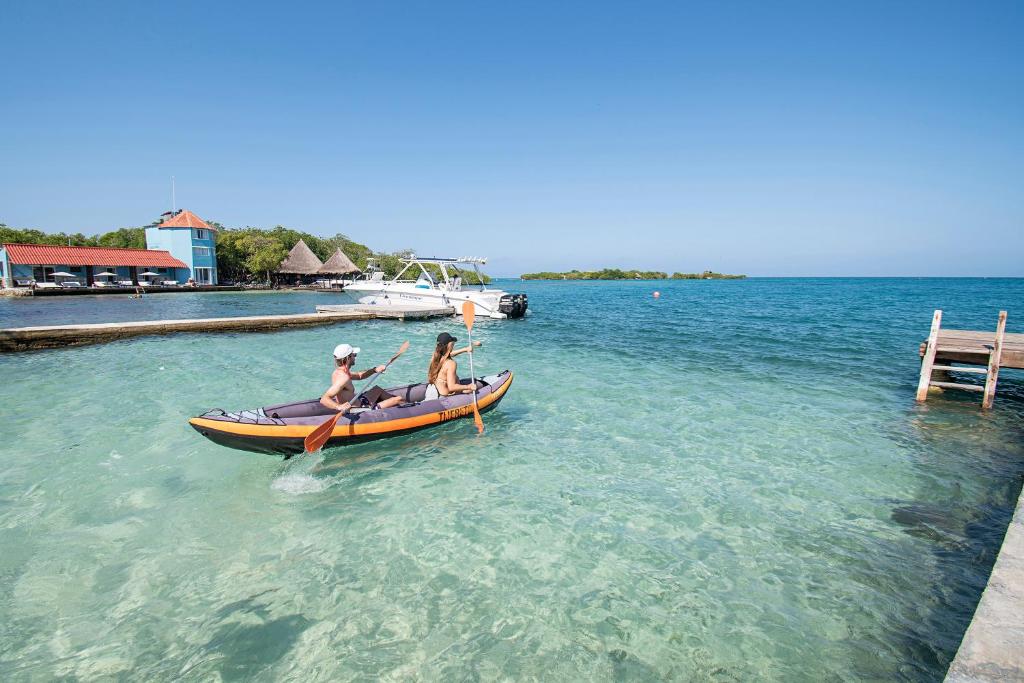 two people are in a canoe in the water at Isla Tijereto in Isla Grande