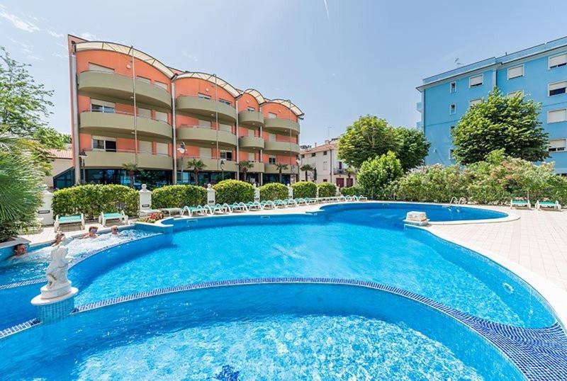 una grande piscina blu di fronte a un edificio di Residence Myricae a Bellaria-Igea Marina