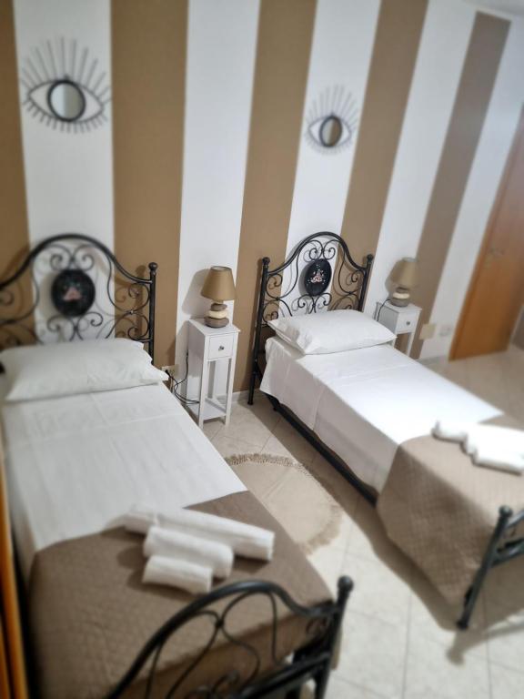 two twin beds in a room with two tables at MARY FAMILY HOME in Polverigi