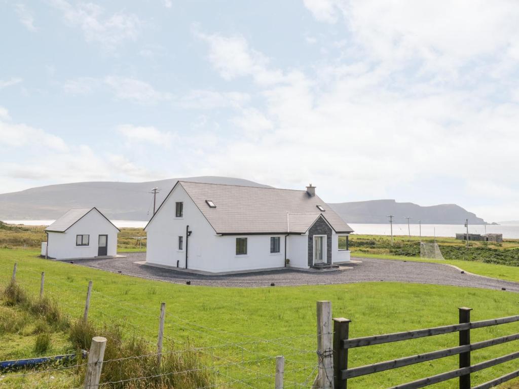 una casa blanca en un campo con una valla en Purteen, en Achill