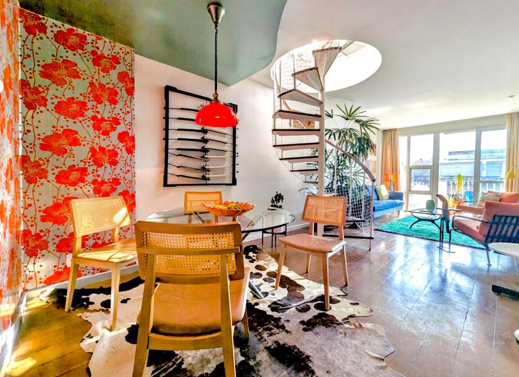 a living room with a spiral staircase and a table and chairs at Ipanema Duplex Penthouse in Rio de Janeiro